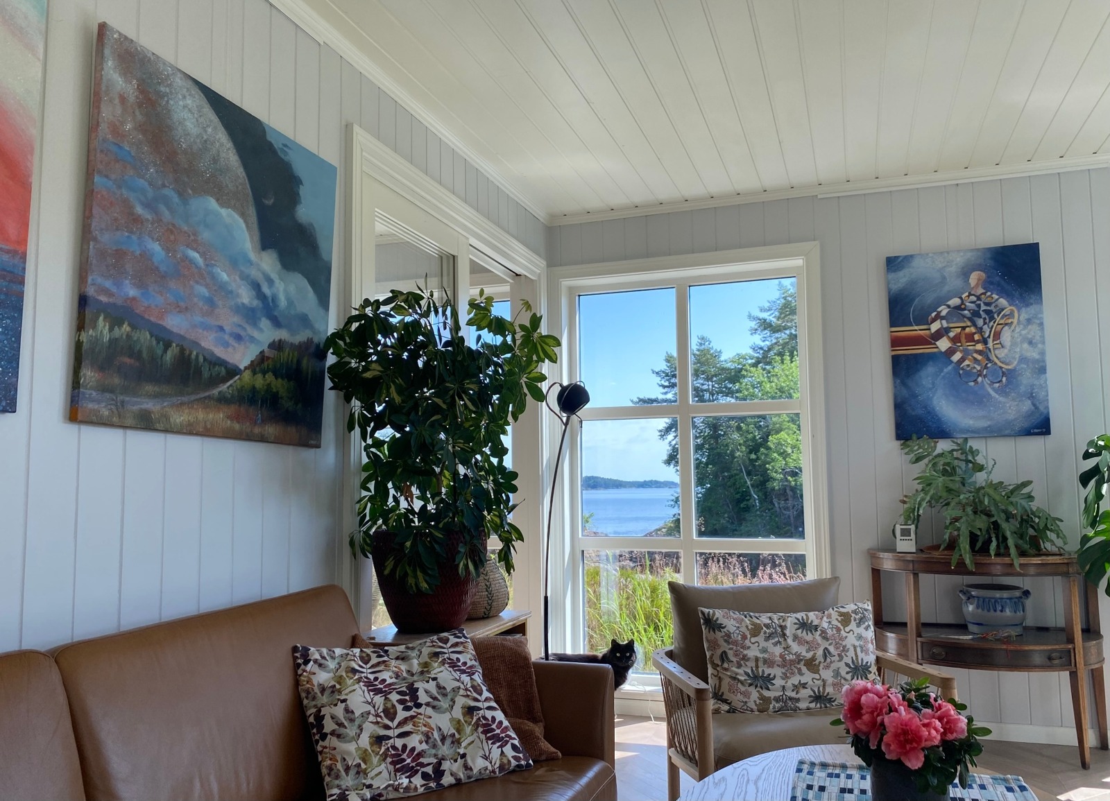 Hjemmegalleriet på Borøy med malerier på veggene og utsikt mot sjøen